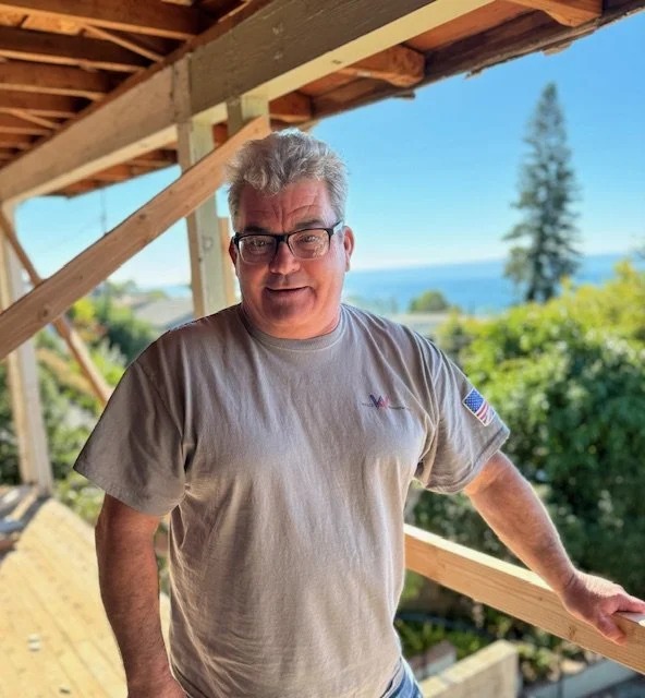 Jason Welch on site in Laguna Beach, framing overhead and the ocean behind him