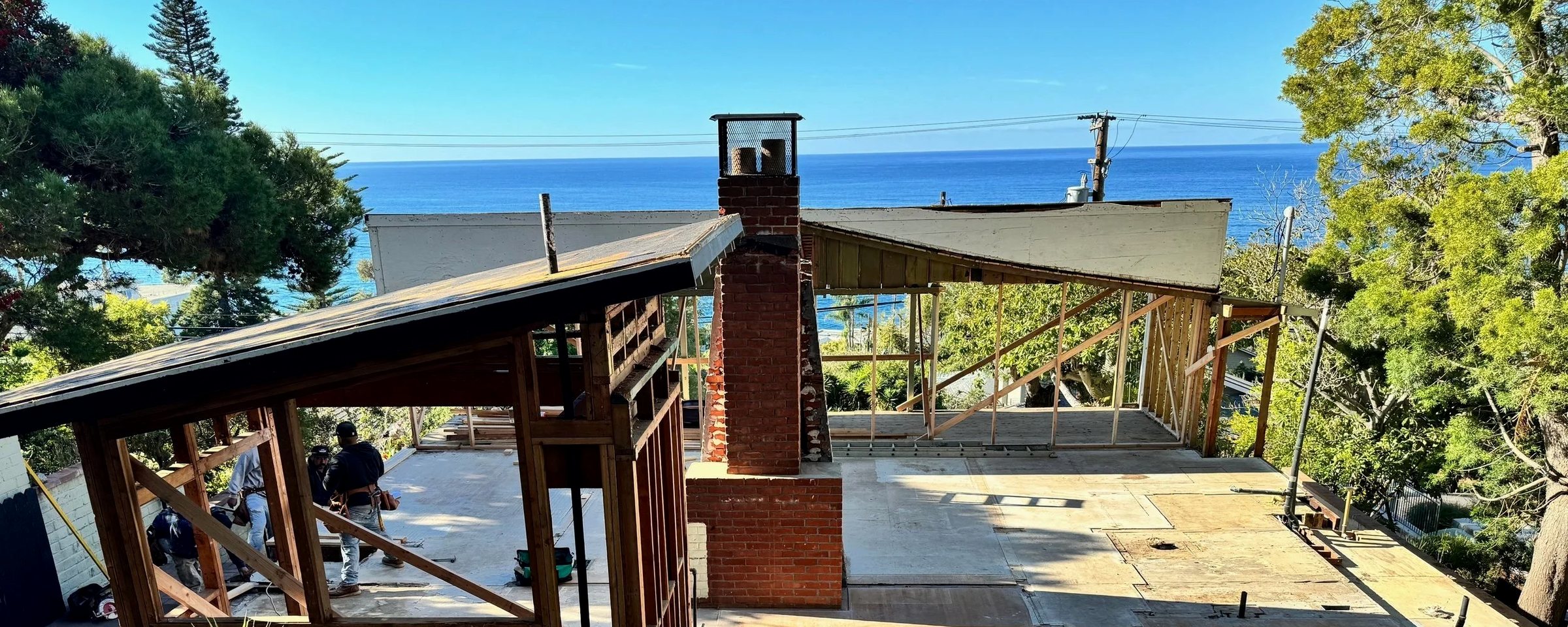 A Laguna Beach house opened to its frame during construction, the Pacific behind it