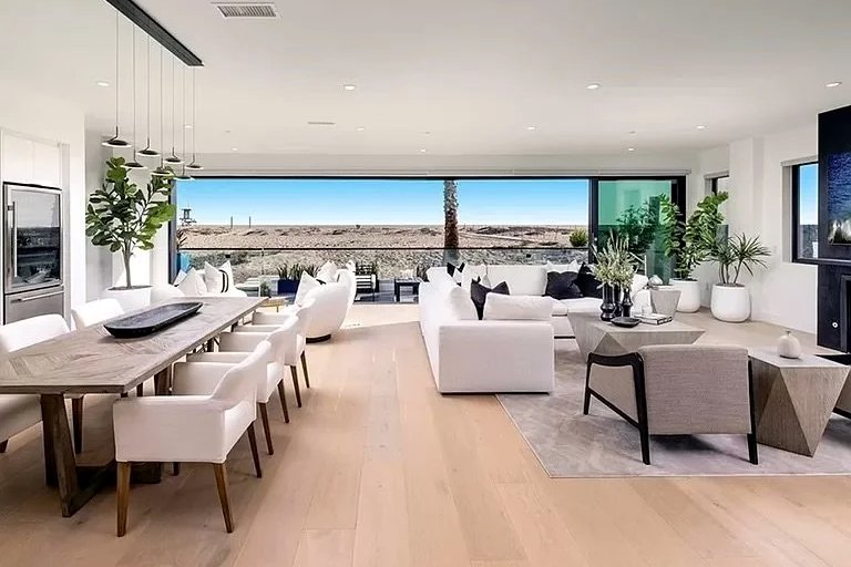 A Newport Beach living and dining room opening to a terrace above the sand