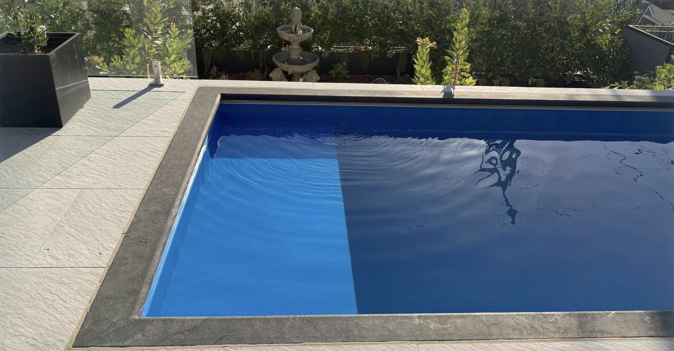 The pool at the end of the day, with the fountain and the planting behind it