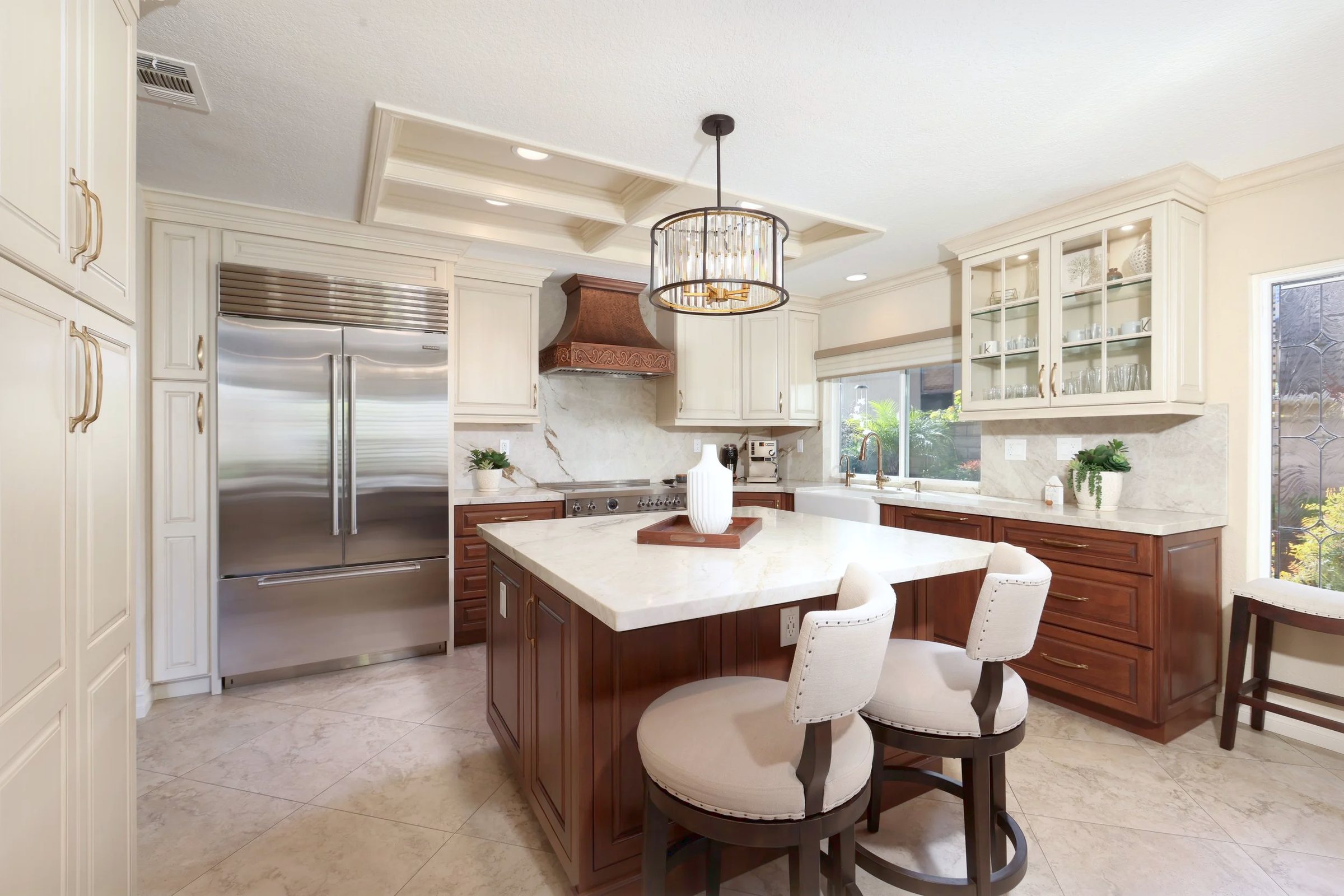 The kitchen from the doorway, cherry island under a drum pendant with painted cabinetry around it