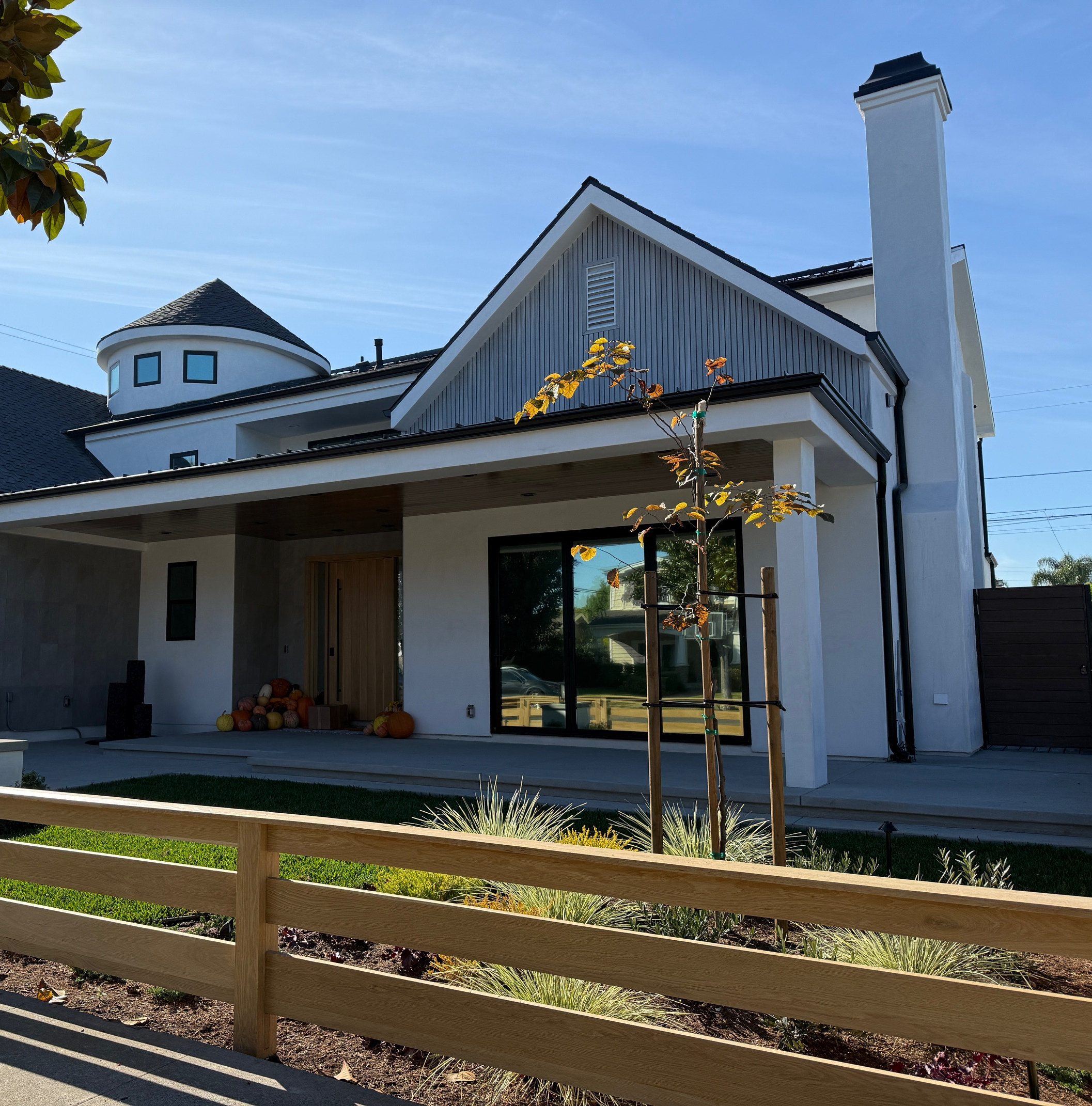 The finished Los Alamitos house from the street, the turret and gable above a deep front porch