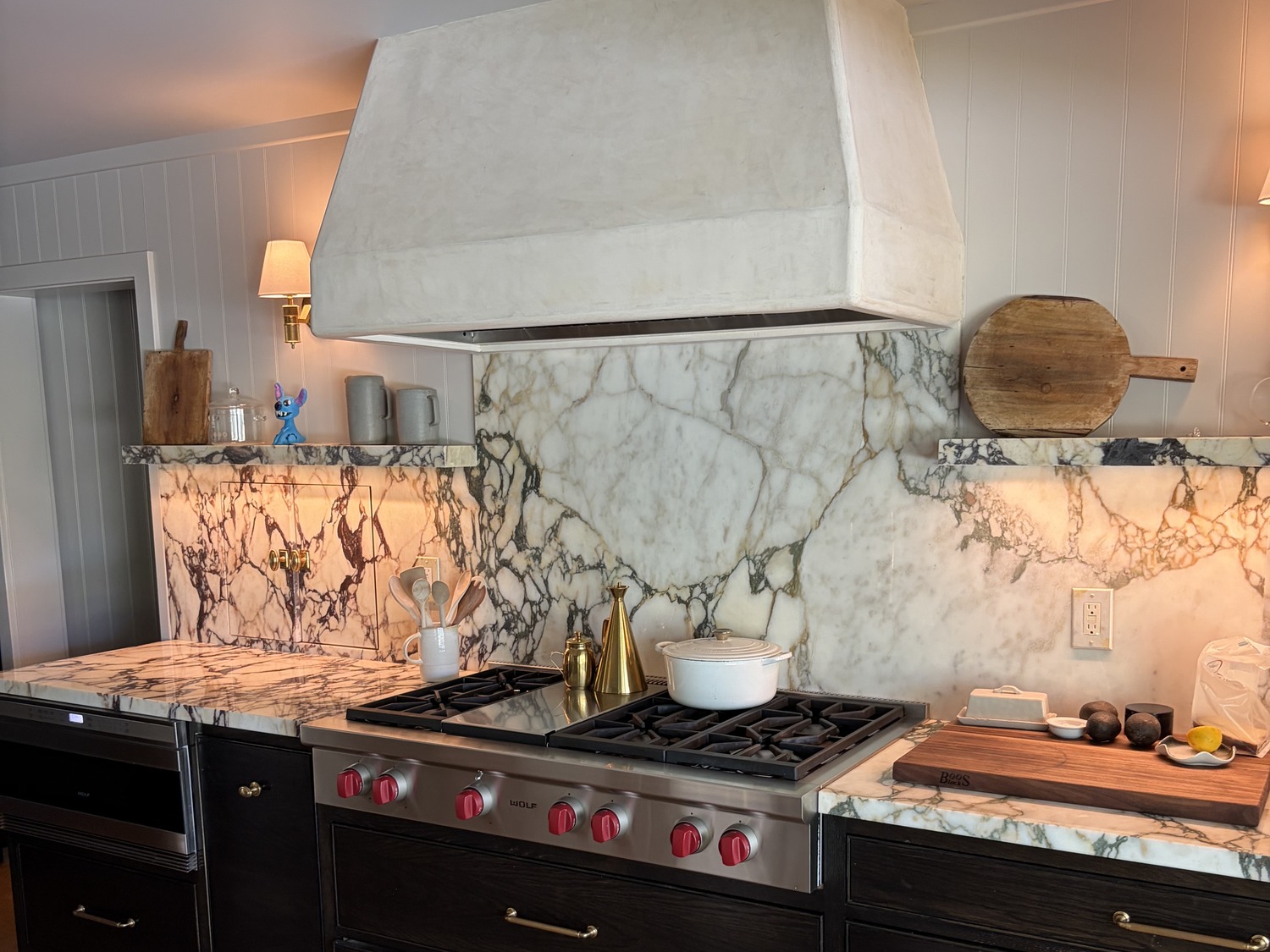 The plaster hood over the range, with the marble carried from the counter to the ceiling behind it