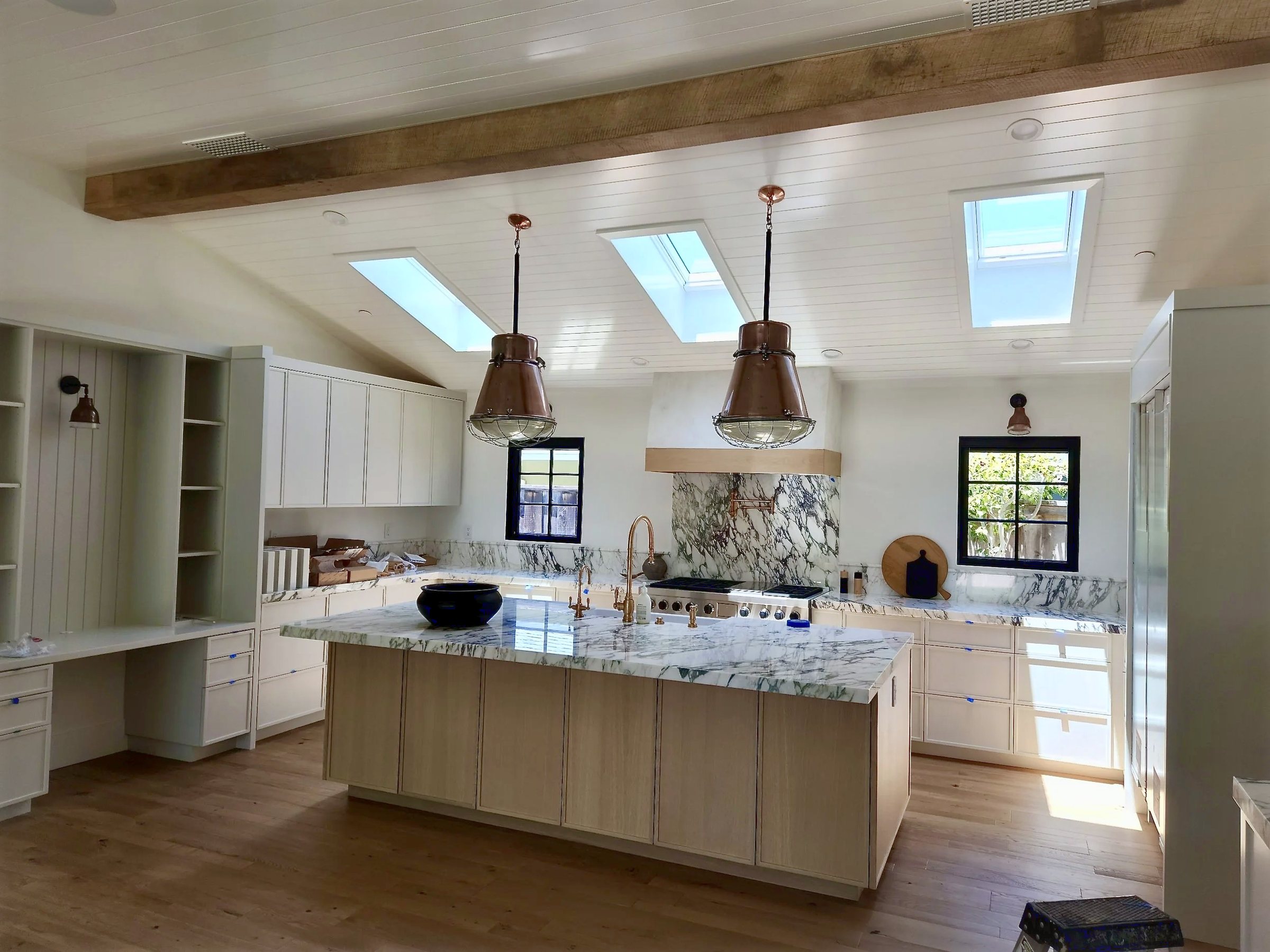 The kitchen under the opened roof, one exposed beam and three skylights above the island