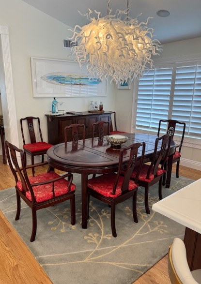 The dining room before the remodel, a glass chandelier over a dark wood table.