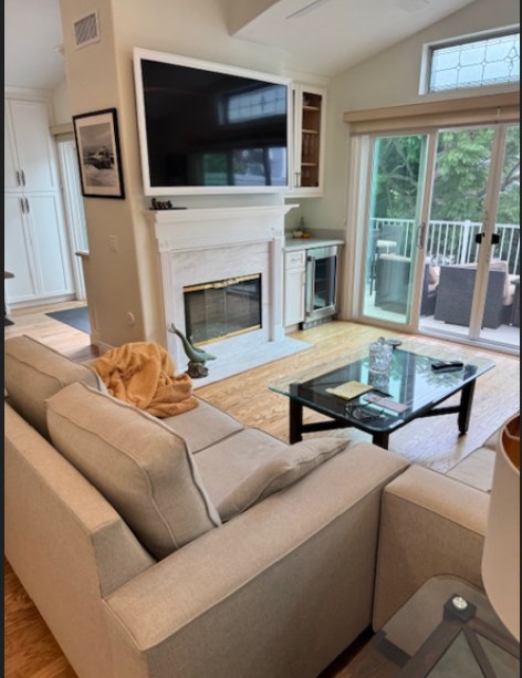 The living room before work, a sectional facing the fireplace and the doors out to the deck.
