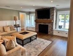 The finished living room, the brick fireplace kept and framed by new white built-ins.