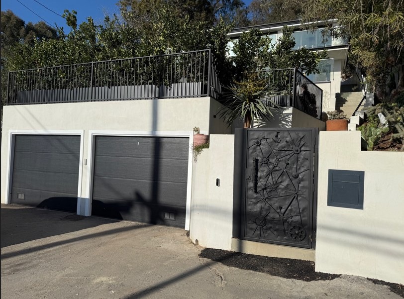 The finished frontage, two garage doors and a cast metal gate set into the new wall.