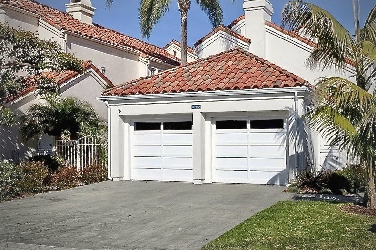 The house from the street, unchanged, tile roof and white garage doors