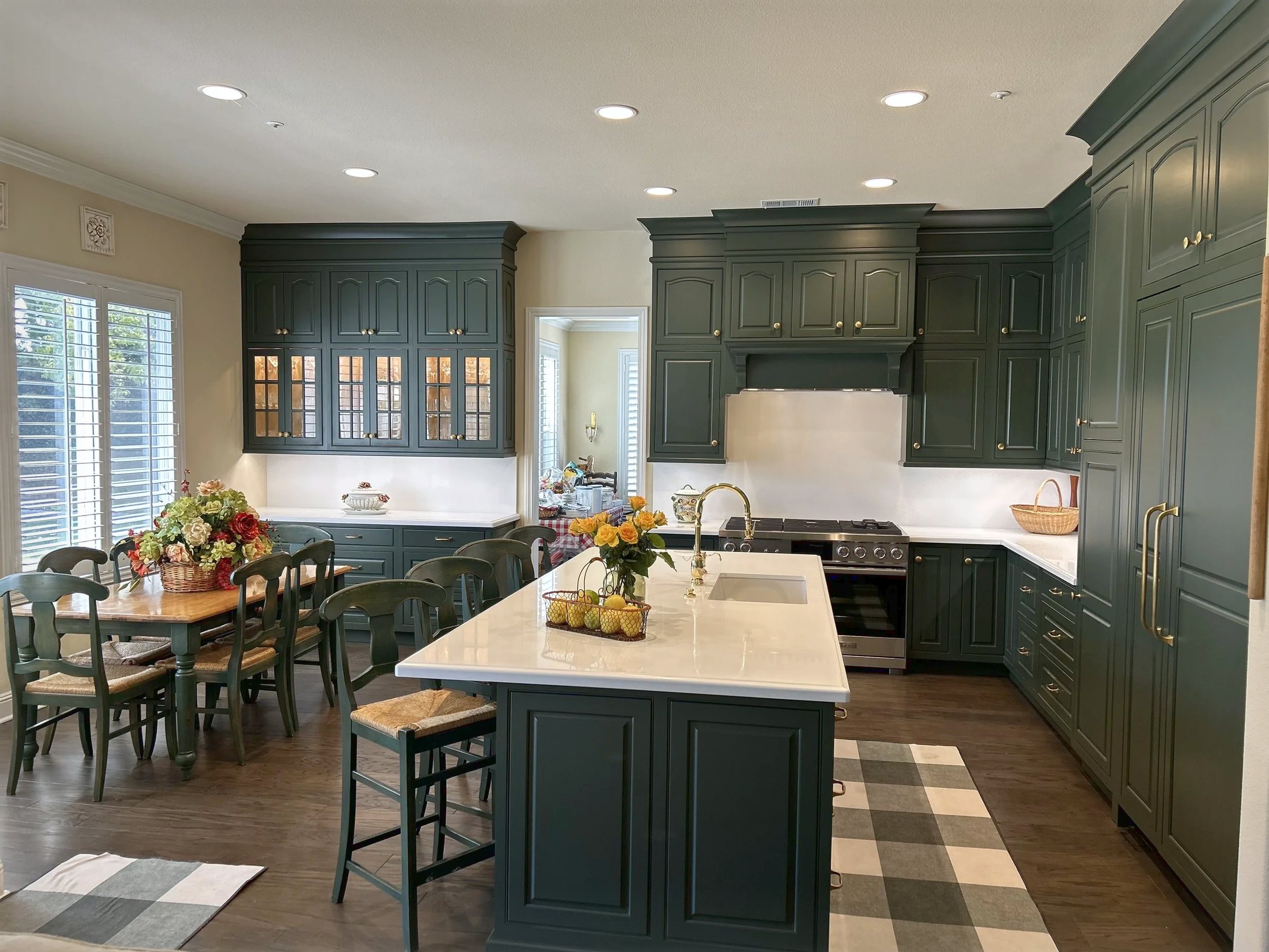 The English green kitchen carried full height on every wall, the table in the same room